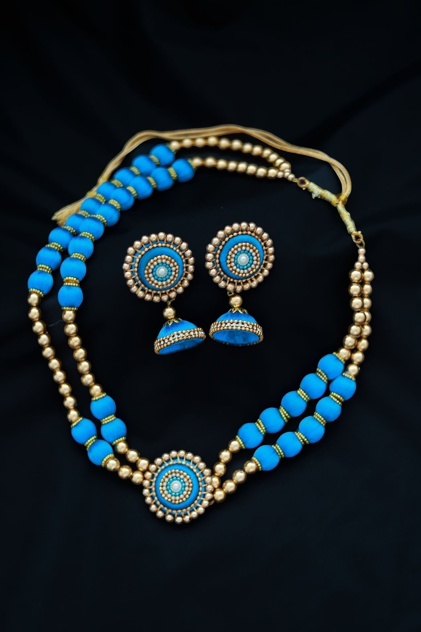 Gapochi choker necklace and jhumka earring set featuring light blue and gold round beads on a black background